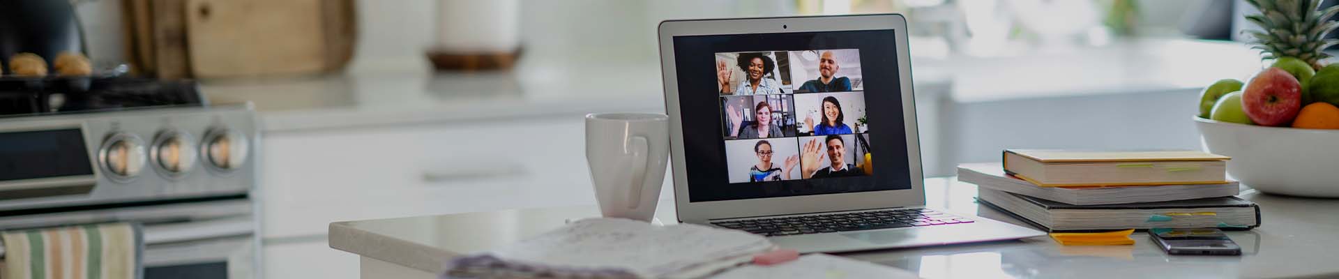 Laptop in home environment showing video call with six people