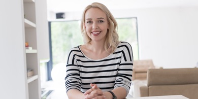 Female manager smiling, sitting in a sunny room