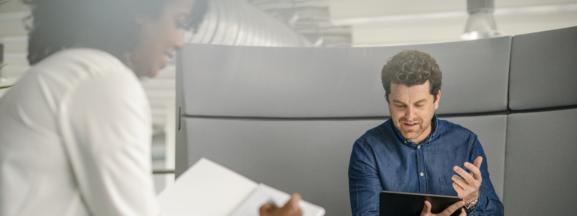 White middle-aged man discuss with black woman over tablet