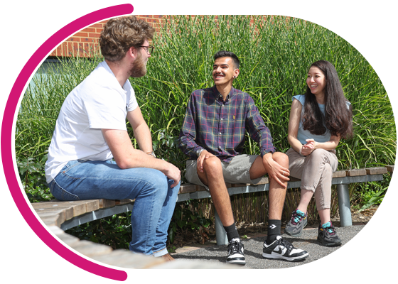 Image of two men and a woman sat on bench laughing