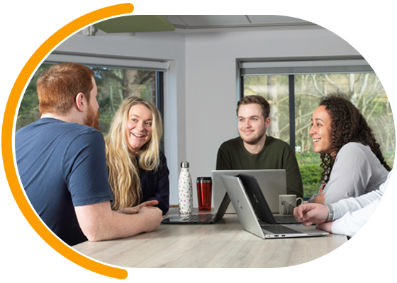 Group of Ageas employees sat around a table smiling