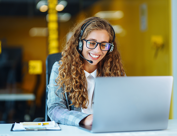 Employee smiles at laptop.