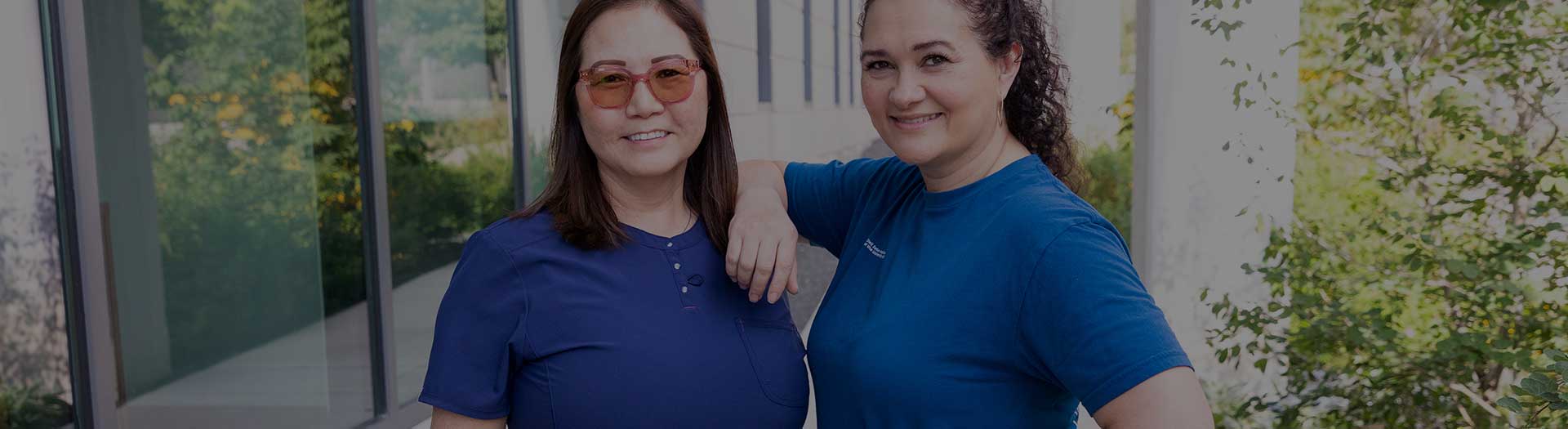 Page Header Image - Ascension Physician Support - Two female medical professionals in scrubs, outside, smiling into camera