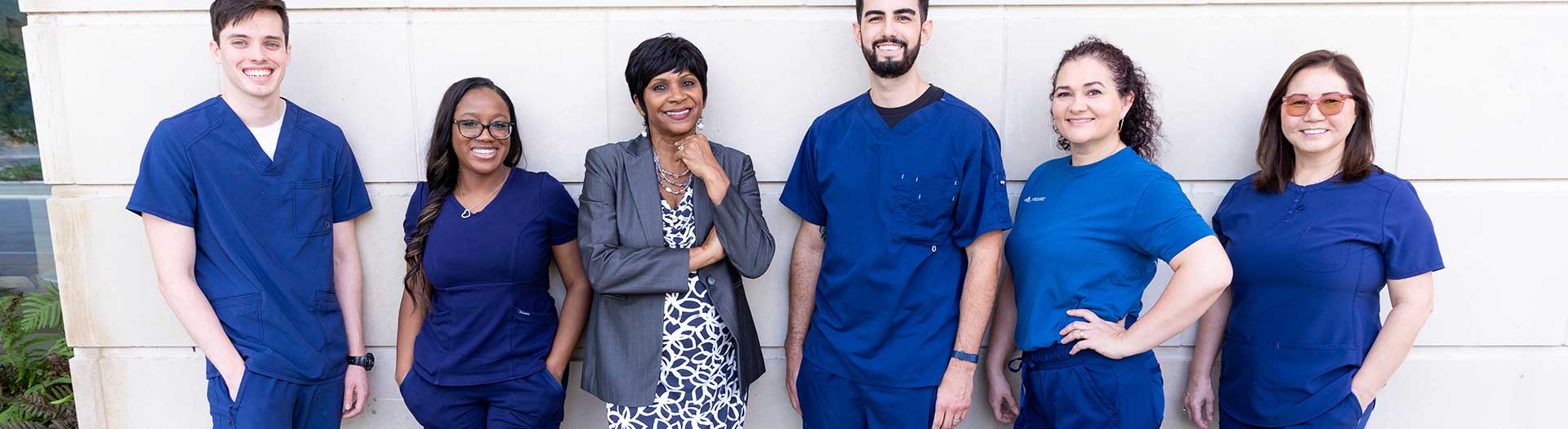 Page Header Image - Ascension Diversity & Inclusion - Diverse group of medical professionals, along wall, smiling into camera