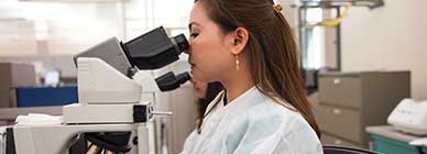 Tile - Ascension Allied Health Laboratory - Lab tech peering through microscope