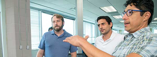 Tile - Technology Studios - Three men reacting to whiteboard content