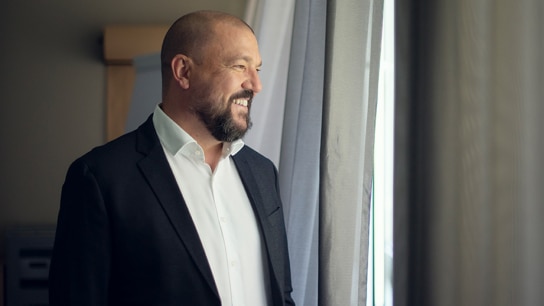 Smiling man looking out of the window