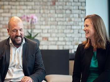 Two people laughing and sitting next to each other