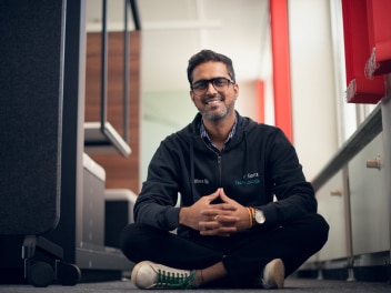 Allianz colleague sitting on the floor with cheerful expression