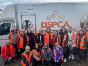 People in front of DSPCA truck wearing ornage jackets 