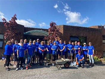 Group of people all wearing blue in front of a building