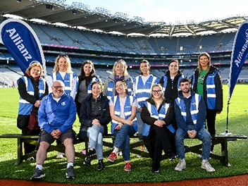 Group of People in a stadium, all wearing blue Allianz clothes