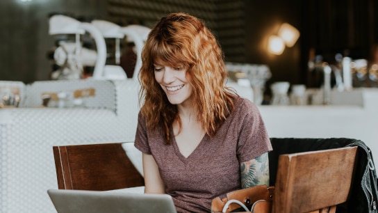 Lächelnde Allianz Mitarbeiterin sitzt vor ihrem Laptop