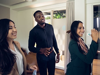 Trois collaborateurs souriants de l'Alliance travaillent ensemble