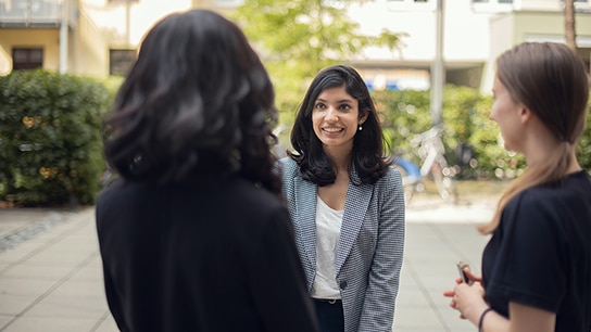 Three colleagues engaged in a conversation