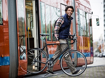 A young man stepped off the bus, bringing his bicycle with him