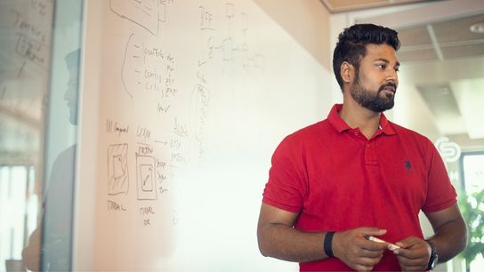 Allianz colleague in front of a whiteboard, engaged in a discussion