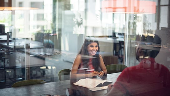 Two employees sitting across from each other, sharing a joyful conversation.
