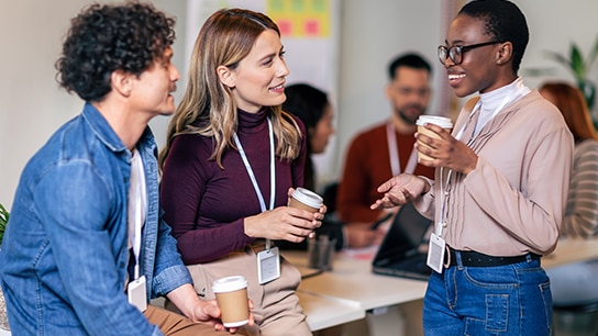 Drei Menschen mit Kaffee unterhalten sich