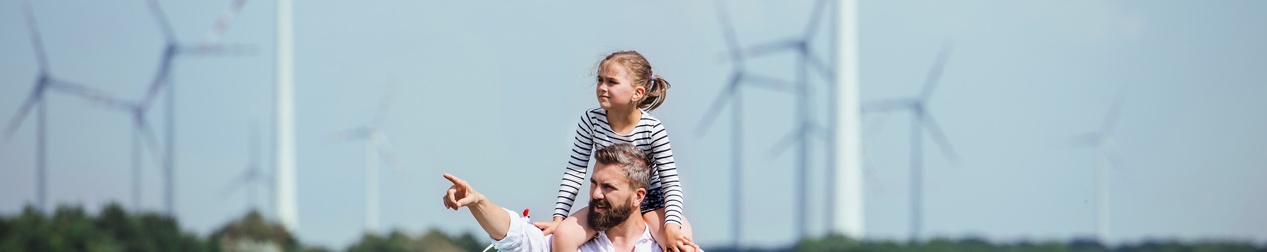 Mann mit Kind auf den Schultern im Windpark