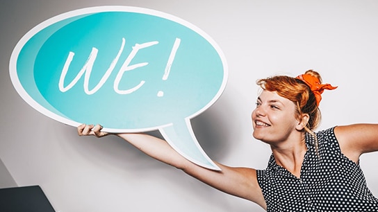 Woman holding a large 'WE' text bubble
