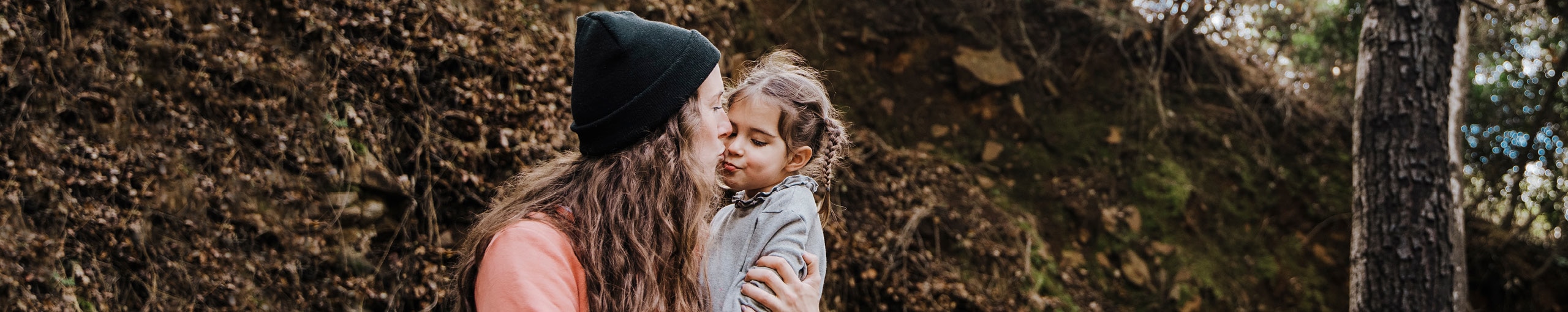 Mãe beijando gentilmente seu filho na bochecha, expressando amor e carinho