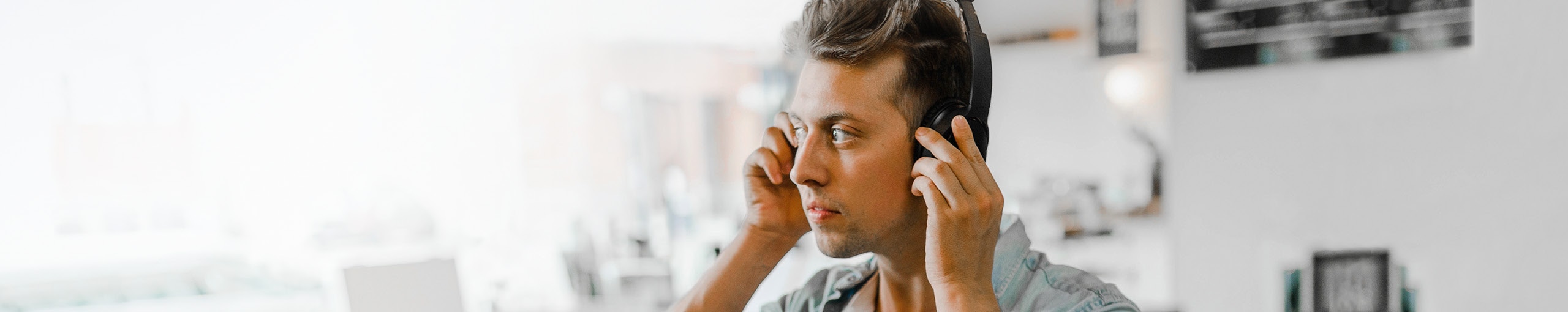 Um jovem com fones de ouvido e parecendo concentrado.