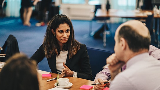 Jovem profissional conversando com colegas seniores