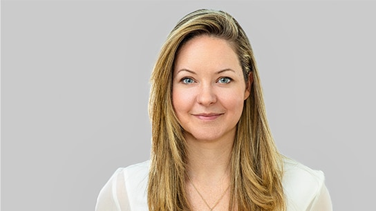 Frau in weißer Bluse vor einer grauen Wand