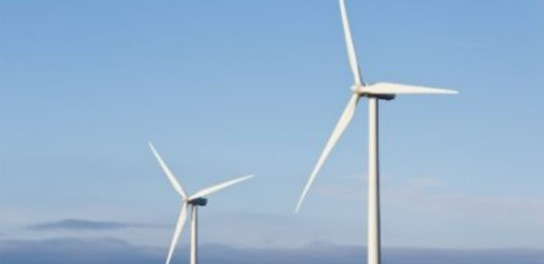 Deux éoliennes tournent contre le ciel bleu