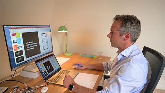 De man zit achter de computer