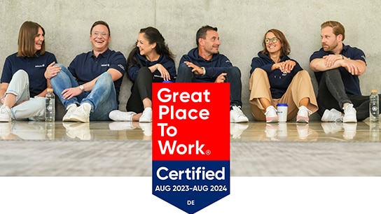 GPTW Award und im Hintergrund Mitarbeiter der Allianz welche auf dem Boden sitzen und lachen