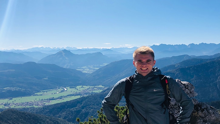 Mann beim wandern vor einer Landschaft mit Bergen
