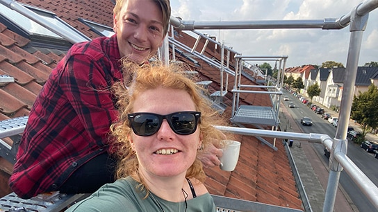 Zwei Menschen auf einer Dachterrasse 