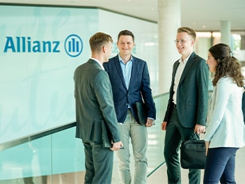 Mehrere Menschen in einem Bürogebäude mit Allianz Logo im Hintergrund