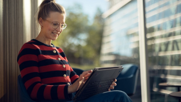 A cheerful employee interacting with her laptop