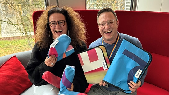 Zwei Menschen am lachen in einem Bürogebäude