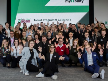 Gruppe von Menschen die dir Hände in die Höhe strecken
