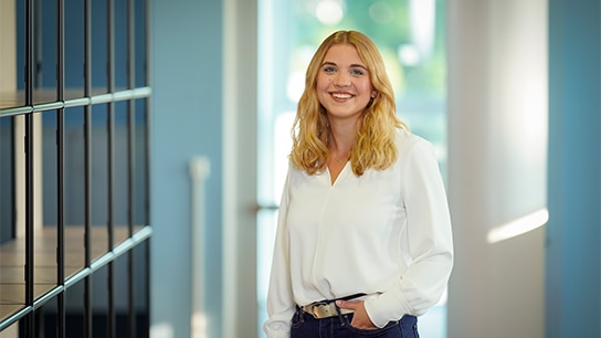 Frau in weißer Bluse in Büroflur