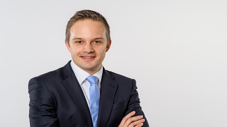 Mann in Anzug vor weißer Wand
