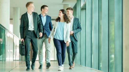 Allianz Mitarbeiter laufen einen Flur entlang
