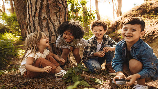 Kinder spielen gemeinsam in der Natur im Wald