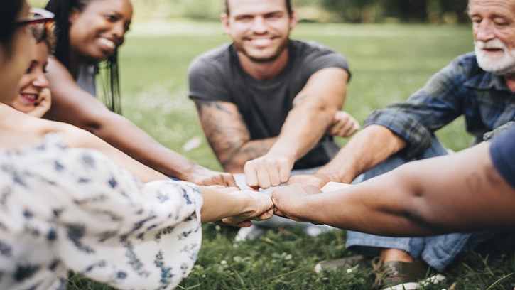 Menschen bilden mit ihren Händen einen Kreis in der Natur