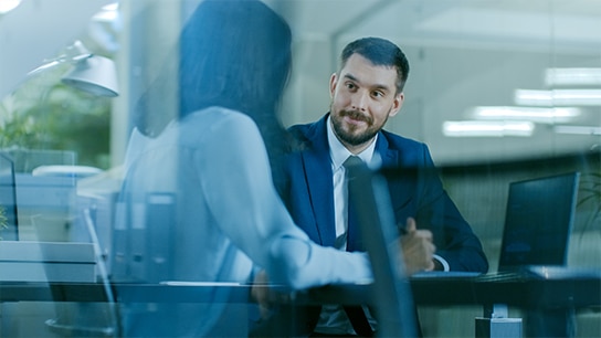 Zwei Mitarbeoter die gemeinsam etwas besprechen