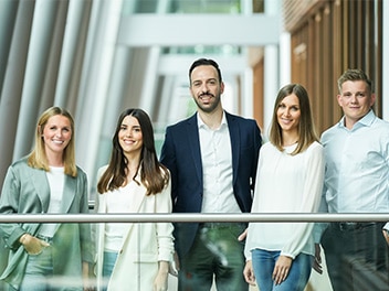 Fünf Mitarbeiter in einem Büroflur