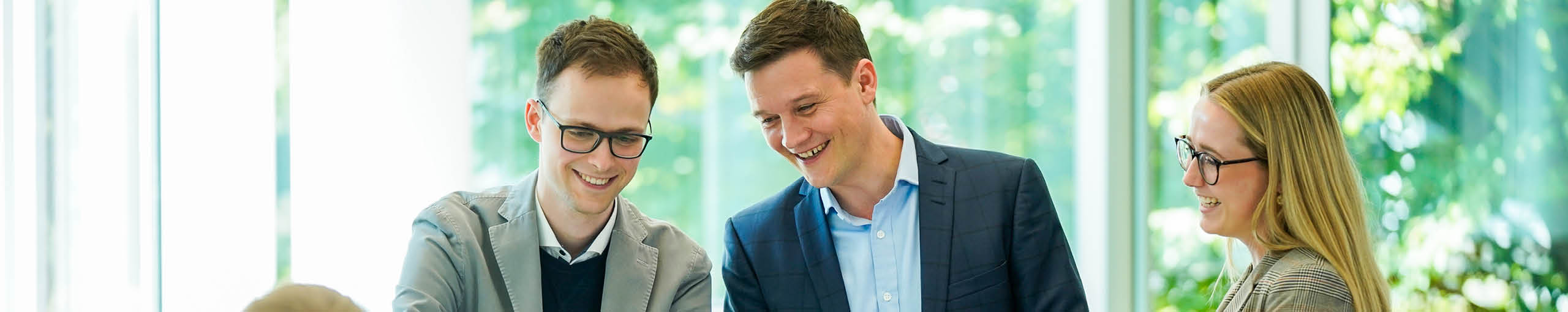 Drei Kollegen stehen gemeinsam da und reden