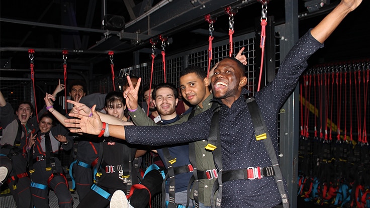 Un groupe de personnes faisant des gestes de victoire, excitées et prêtes pour une aventure.