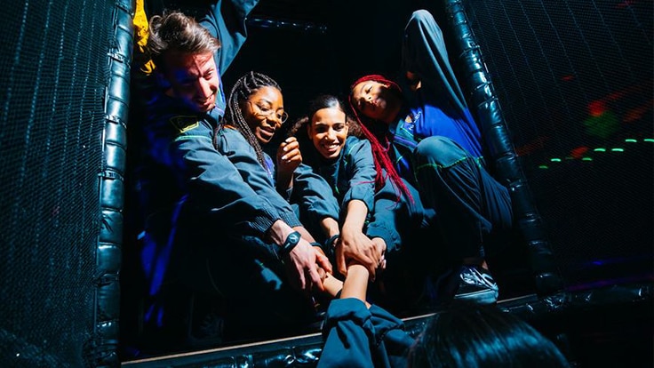 Un groupe de personnes donnant joyeusement un coup de main pour sauver ou soutenir leur coéquipier pendant un match.