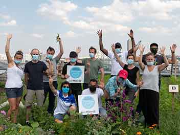 Un groupe de collègues portant des masques faisant un geste de « victoire »