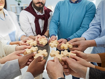 Menschen welche Puzzleteile in ihren Händen halten